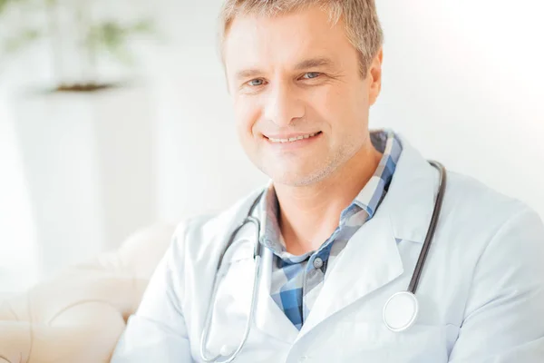 Médico de perspectiva confiado sonriendo y mirando recto . —  Fotos de Stock