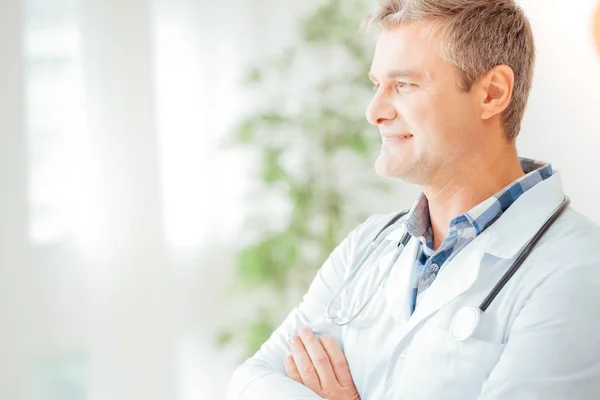 Médico guapo confiado mirando a un lado y sonriendo . —  Fotos de Stock