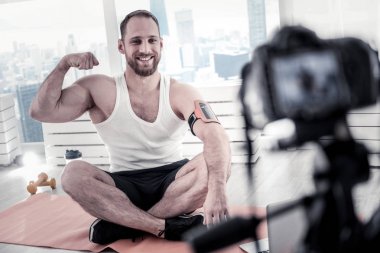 Neşeli erkek blogger gösteren pazı