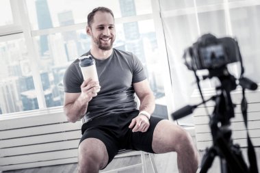 Neşeli erkek blogger egzersiz yaptıktan sonra rahatlatıcı