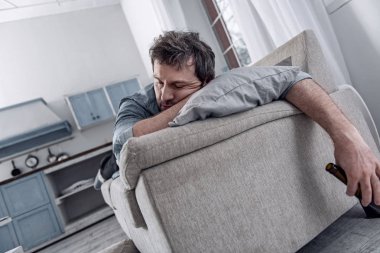 Yorgun adam alkol içtikten sonra bir şişe ile uyuya