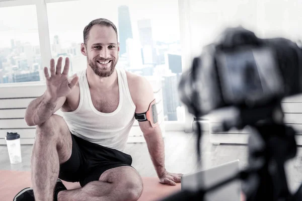 Attractive male blogger greeting viewers