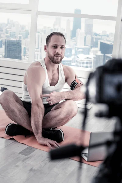 Blogger masculino inteligente apuntando a bíceps —  Fotos de Stock