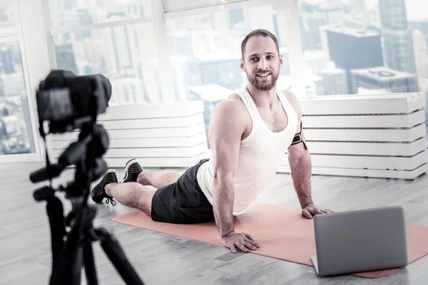 Blogger masculino atraente relaxando músculos da barriga — Fotografia de Stock