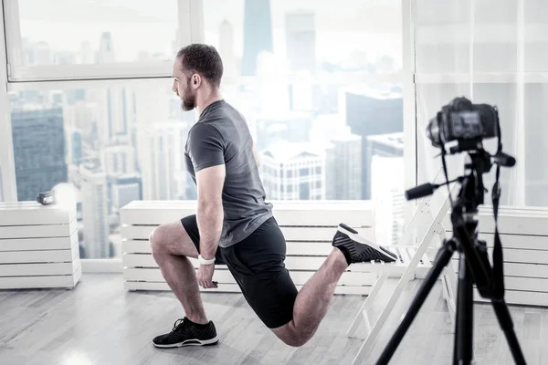 Blogger masculino concentrado entrenamiento piernas músculos —  Fotos de Stock