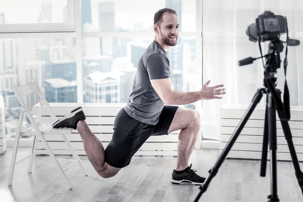 Alegre blogger masculino mostrando ejercicio simple —  Fotos de Stock