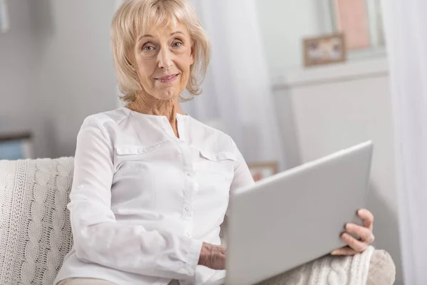 Довольна зрелая женщина отдыхает с ноутбуком — стоковое фото