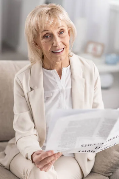 Elegant mature woman holding newspaper