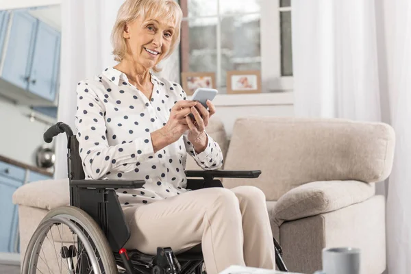 Reife behinderte Frau schaut durch die sozialen Medien — Stockfoto