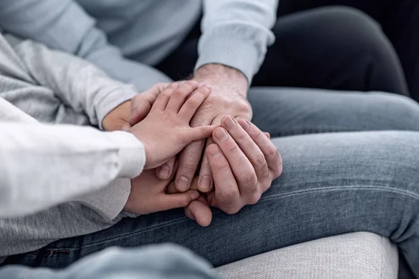 Liten pojke att sätta handen i händerna på hans föräldrar — Stockfoto