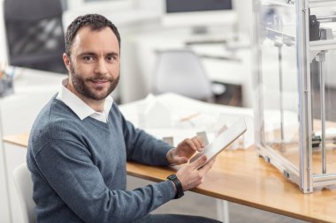 Neşeli mühendisi iş yerinde mola sırasında tablet kullanma