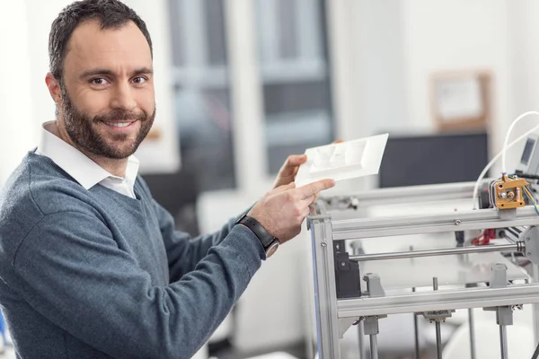Веселий інженер, що показує модель, надруковану за допомогою 3D принтера — стокове фото