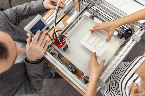 Draufsicht der Ingenieure, die den Prozess des 3D-Drucks wieder aufnehmen — Stockfoto
