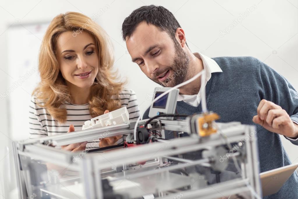 Young engineer explaining principles of 3D printer work