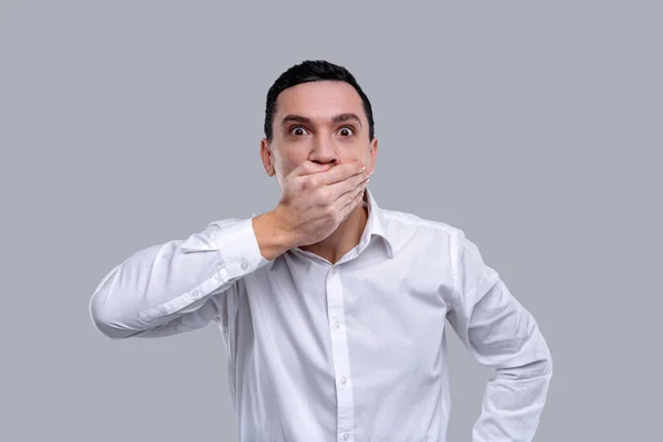 Homem surpreso fechando a boca com as mãos — Fotografia de Stock