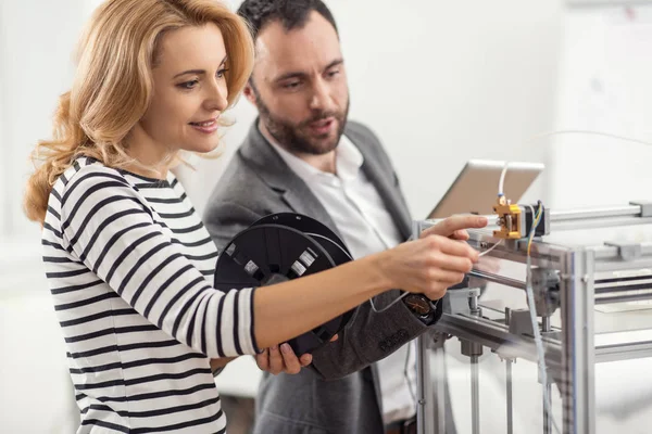 Leitender Ingenieur lehrt, wie man Filament in den Extruder einsetzt — Stockfoto