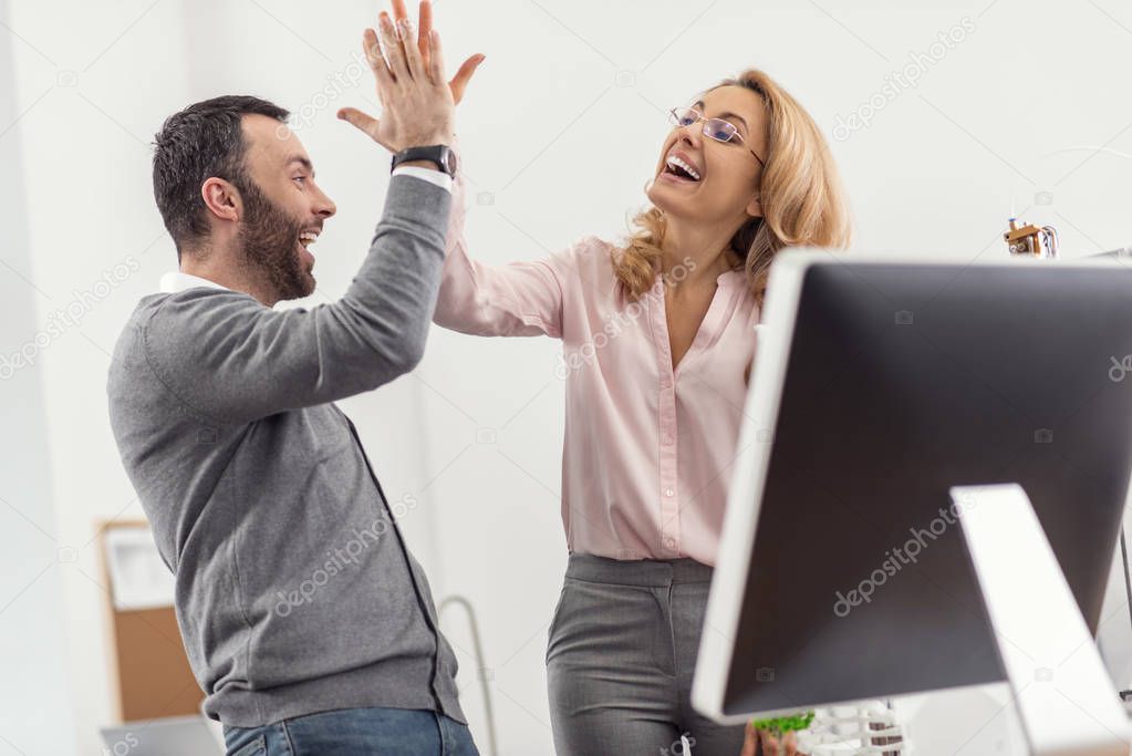 Happy colleagues giving each other a high-five