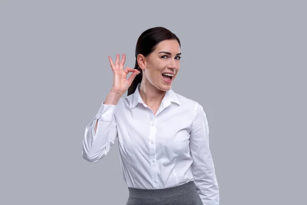 Usmívající se žena ukazuje ok s prsty — Stock fotografie