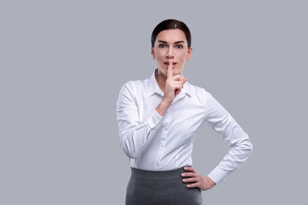 Excited woman having her index finger near her lips — Stock Photo, Image