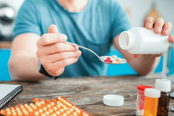 Helpful natural vitamins falling in the spoon. — Stock Photo, Image