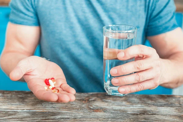 Drogas úteis coloridas estando na mão dos homens . — Fotografia de Stock