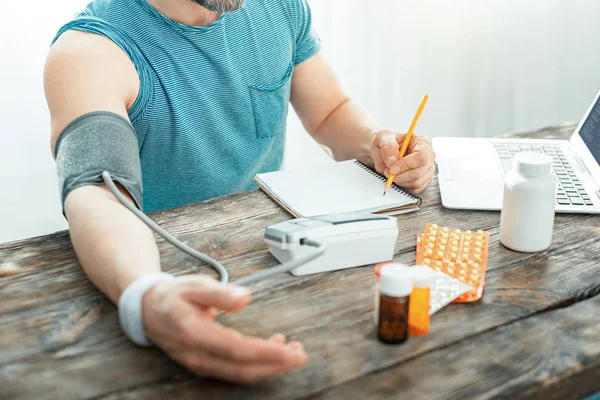 Bezet verantwoordelijk man pols meten en registreren van de resultaten. — Stockfoto