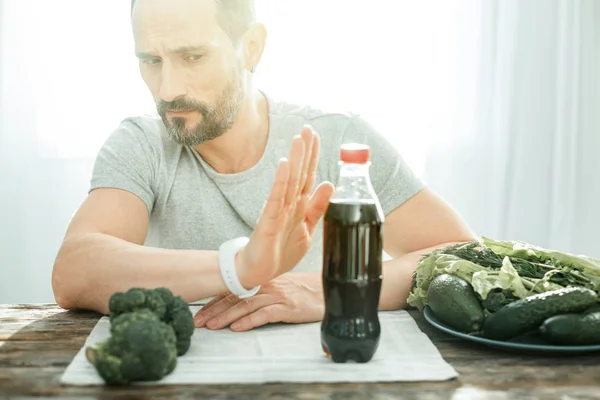 Decisivo hombre serio sentado y negándose a beber . — Foto de Stock