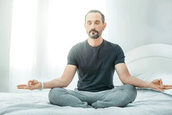 Hombre guapo e inquebrantable sentado y meditando . —  Fotos de Stock