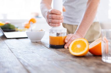 Turuncu taze makine kullanarak güçlü erkek eller