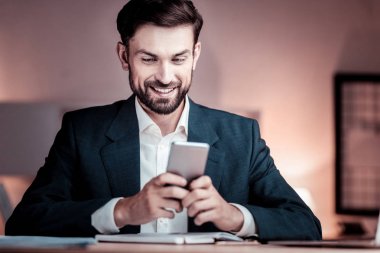 Oturma ve smartphone kullanarak mutlu baktılar adam.