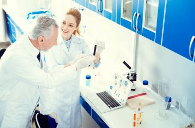 Kadın gösteren iş arkadaşları tüp sıvı ile gülen