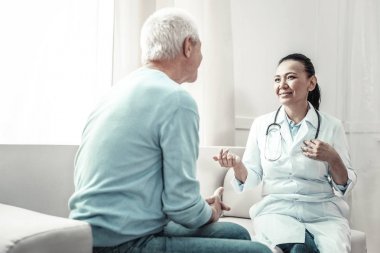 Onunla konuşmayı hasta bakarak keyifli neşeli doktor.