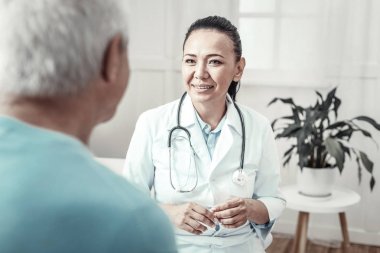 Gülümseyen ve istişare sahip yetenekli şirin hemşire.