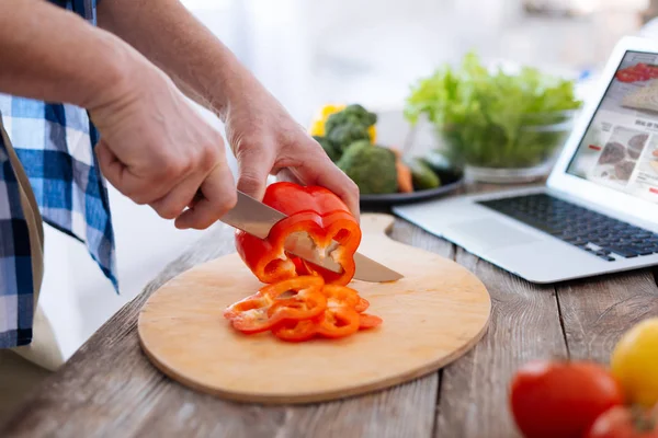 Mannelijke jonge handen kappen paprika — Stockfoto