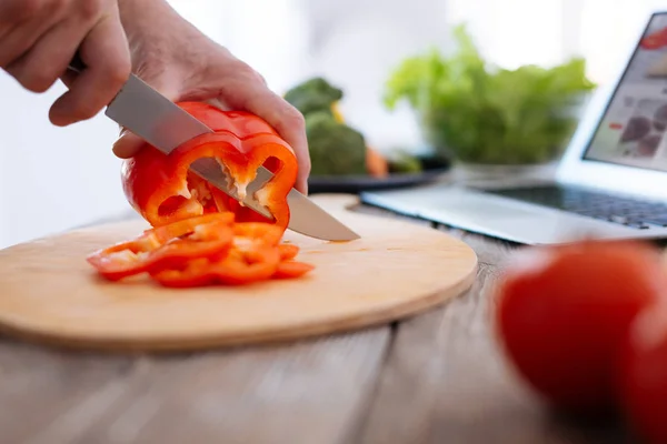 Man sterke handen snijden paprika — Stockfoto