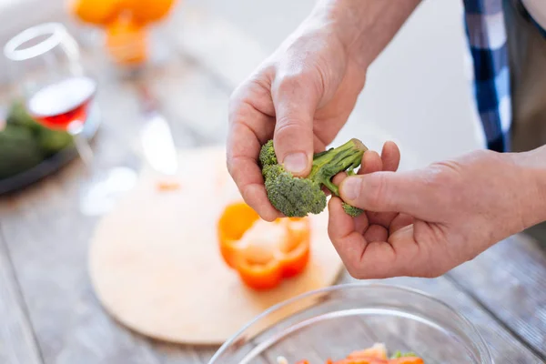 Mannelijke handen broccoli te verdelen in stukken — Stockfoto