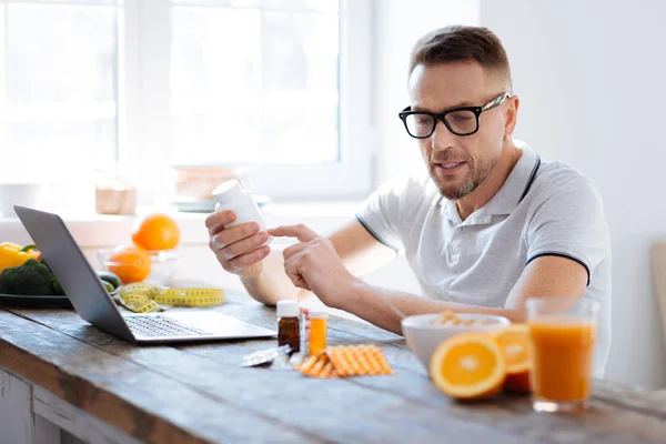 Busy attentive man studying pills for biohacking — Stock Photo, Image