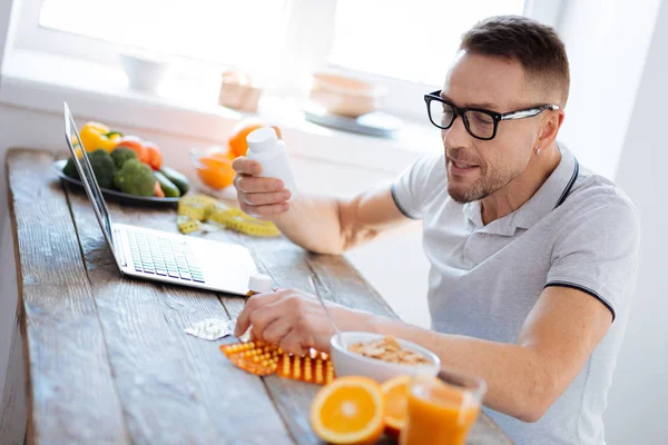 Blij dat aantrekkelijk man op zoek naar biohacking supplementen — Stockfoto