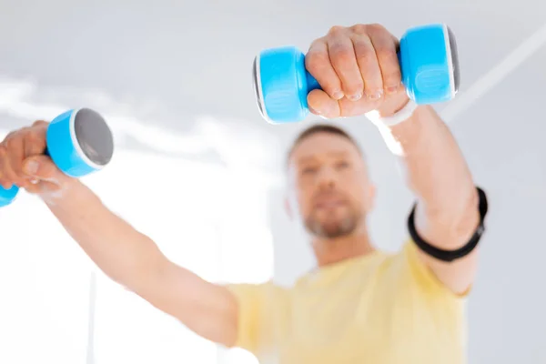 Nice pretty man warming up with dumbbells — Stock Photo, Image