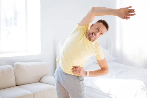 Energetico uomo entusiasta cercando tecniche di stretching — Foto Stock