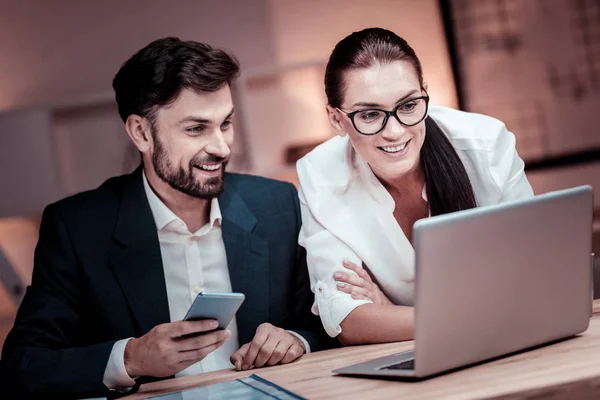 Parceiros confiáveis qualificados sentados e trabalhando com o laptop . — Fotografia de Stock