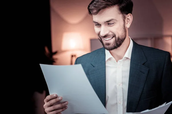 Interessado trabalhador inteligente de pé e lendo o documento . — Fotografia de Stock