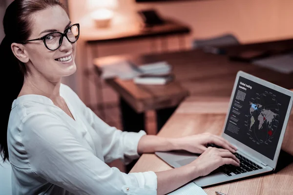 Zufriedene, selbstbewusste Mitarbeiter sitzen und den Laptop benutzen. — Stockfoto