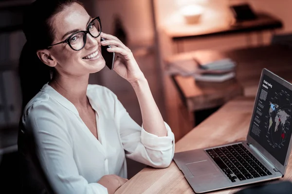 Bezette aangename vrouw gesprek en het gebruiken van laptop. — Stockfoto