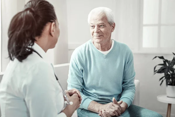 Starzec przyjemny siedząc i rozmawiając z lekarzem. — Zdjęcie stockowe