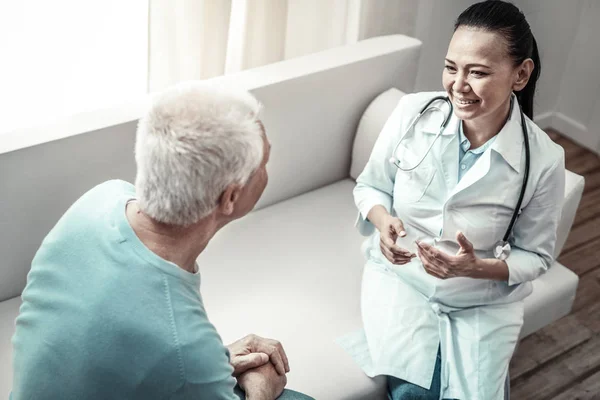 Freudig hübsche Krankenschwester spricht und gestikuliert. — Stockfoto