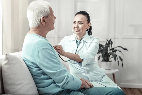 Enfermera joven y experta sentada y escuchando a los pacientes pulmones . — Foto de Stock