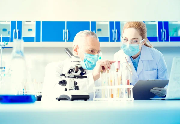 Serious researches conducting experiment in lab — Stock Photo, Image