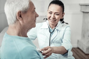 Yapan yaşlı hoş erkek hemşire emir ve oturan.