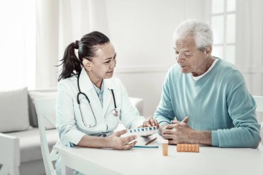 Oturma ve hapları öğretim açıklayan sorumlu ciddi doktor.